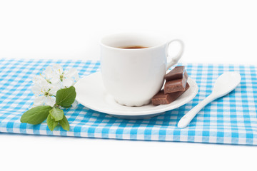 Coffee cup with chocolate and a sprig of cherry blossoms