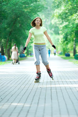 Roller skating sporty girl in park rollerblading on inline skate