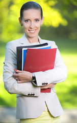 Fototapeta premium Portrait of smiling business woman with paper folder. Student