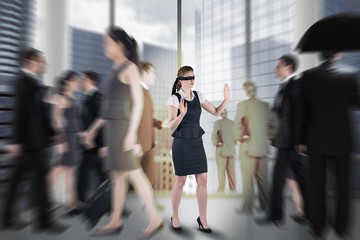Composite image of redhead businesswoman in a blindfold