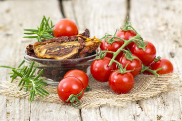fresh and dried tomatoes on wooden background