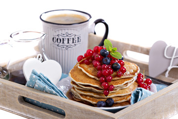 Pancakes with mixed berries isolated on white