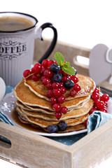 Pancakes with mixed berries isolated on white
