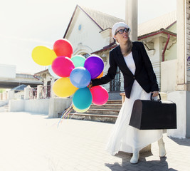 Vintage styled women with balloons waiting for train