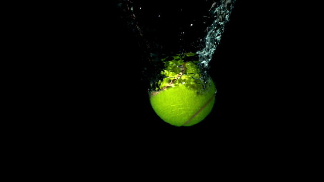 Tennis Ball Falling In Water On Black Background