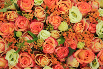 Obraz na płótnie Canvas Orange and yellow roses in a bridal bouquet