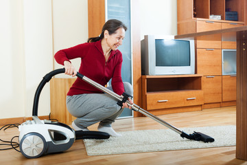  mature woman with vacuum cleaner