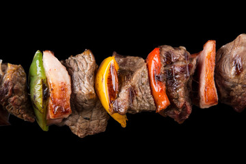 Tasty skewers on black background.