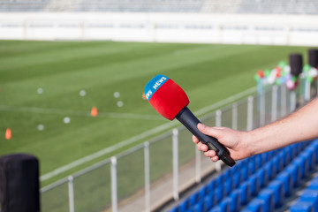 hand holding microphone for interview during a football mach