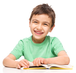 Little boy is reading a book
