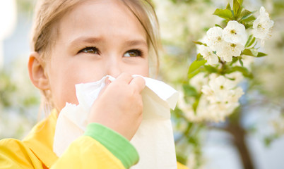 Little girl is blowing her nose