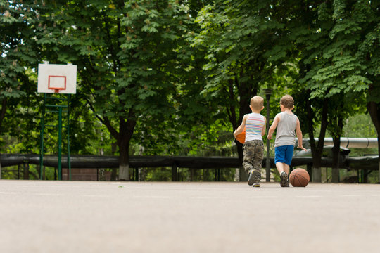 Two young boys walking off a basketball court