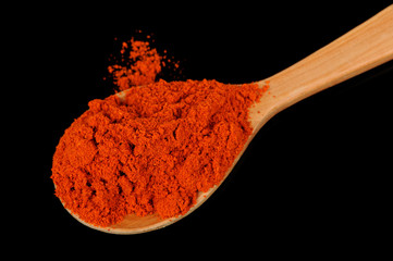 Paprika in Wooden Spoon on Black Background