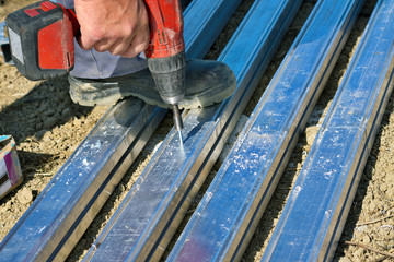 Worker fixing nuts on construction frame