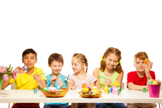 Five kids with colourful Eastern eggs at table