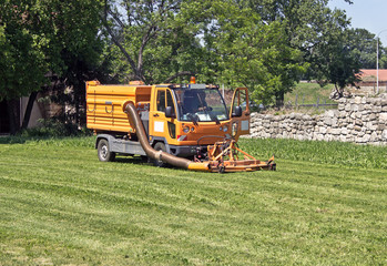 Lawn mower yellow truck cutting grass