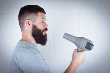 man wipes his beard with hair dryer