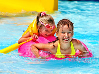 Children in life jacket in swimming pool.