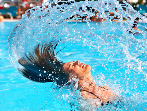 Happy woman in water waving hair