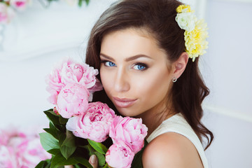 Young Woman in Flowers. Healthy Long Hair and Clean Skin.
