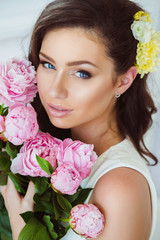 Young Woman in Flowers. Healthy Long Hair and Clean Skin.