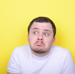 Portrait of funny cluelles man against yellow background