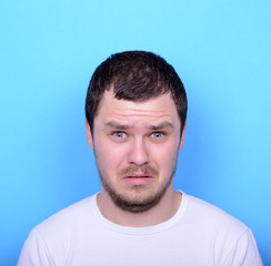 Obraz premium Portrait of man with dusgusted gesture against blue background