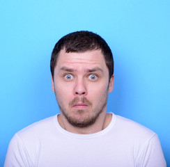 Obraz premium Portrait of man with dusgusted gesture against blue background