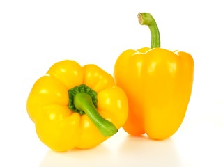 Two yellow peppers over a white background