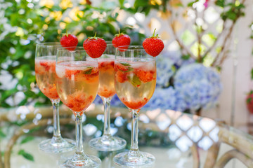 Summer cocktail with champagne, peppermint and fresh strawberrie