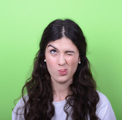 Portrait of girl with funny face against green background