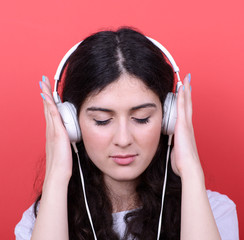 Portrait of happy teen girl dancing and listening music against