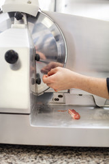 Commercial cook or chef slicing cold meat