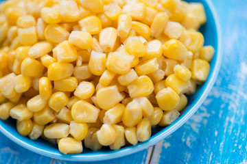 Close-up of sweet corn kernels, blue wooden background