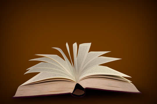Open old book on brown background