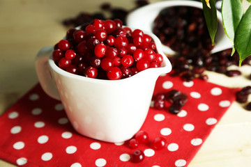 Fresh and dry cranberry in pitchers and bowl