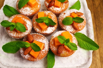 Tasty pumpkin muffins on wooden table