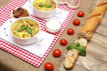 Tasty soup in saucepans on wooden table, close up