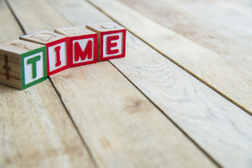 Wooden blocks are Time word on wooden floor