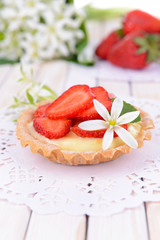 Tasty tartlet with strawberries on table close-up