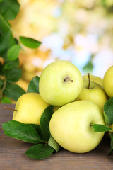Ripe sweet apples with leaves on nature background