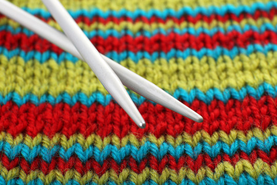 Two knitting spokes and knitted fabric close up