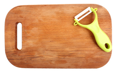 Vegetable peeler and cutting board isolated on white