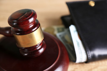 Gavel and money coins on wooden background