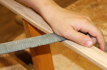 Kind bearbeitet ein Holzstück