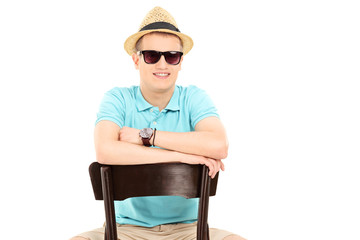 Young man with sunglasses sitting on a chair