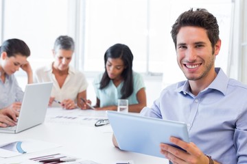 Attractive businessman using a tablet at work