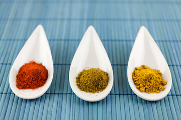 Dried ground spices in ceramic spoons