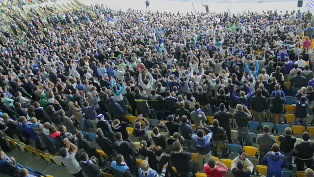 Thousand supporters of football team clap in sync, stadium match