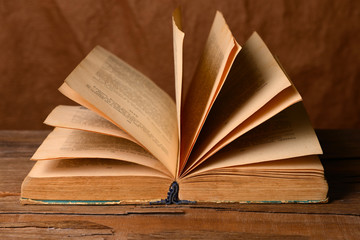 Old book on table on brown background